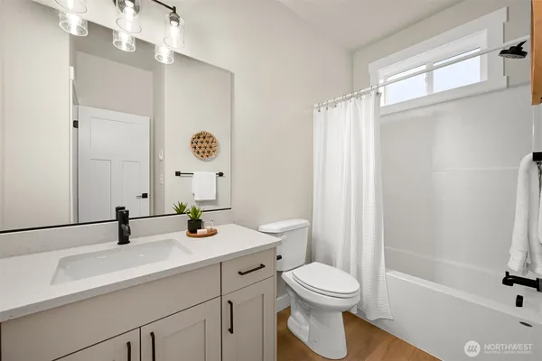 a bathroom with a sink a toilet a mirror and shower