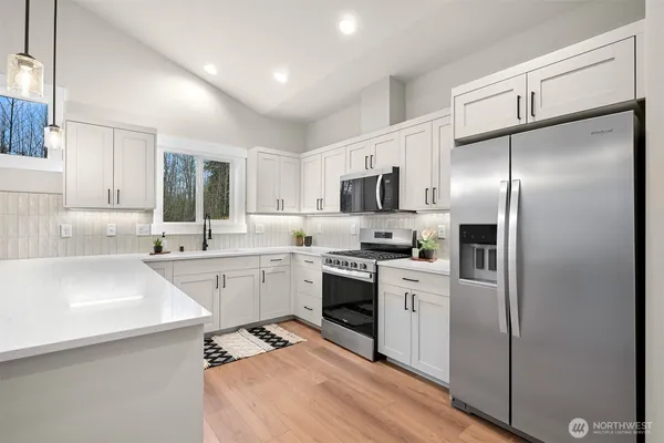 a kitchen with white cabinets stainless steel appliances and sink
