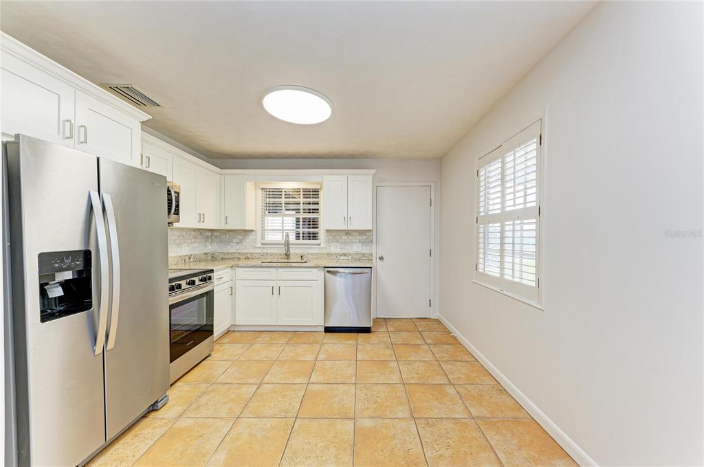 616 Palm Avenue Ellenton, FL 34222 - Photo 17 of 53 a kitchen with a refrigerator a sink and cabinets