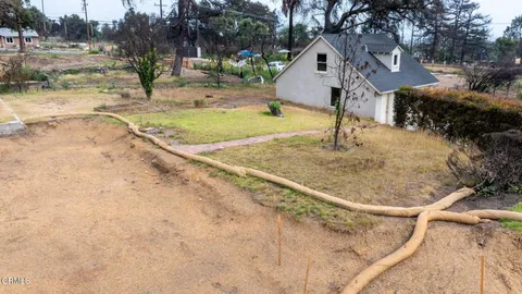 an aerial view of a house with a yard and a large tree