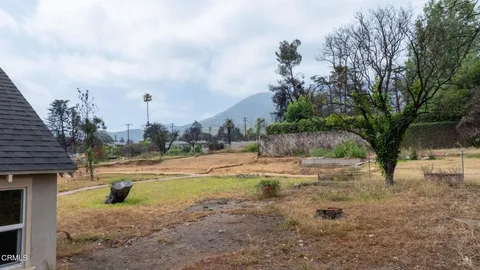 a backyard of a house with lots of green space and fountain