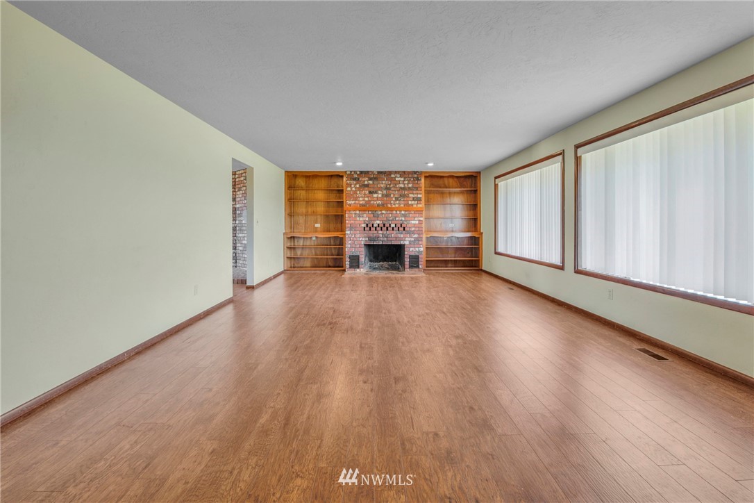 433 Curtis Hill Road Chehalis, WA 98532 - Photo 7 of 22 an empty room with wooden floor fireplace and windows
