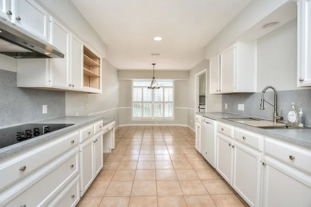 a large kitchen with white cabinets and a stove