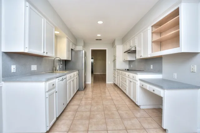 a kitchen with granite countertop white cabinets white stainless steel appliances with a sink and dishwasher