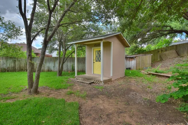 a view of a house with backyard and a tree