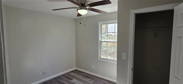 an empty room with windows and fan