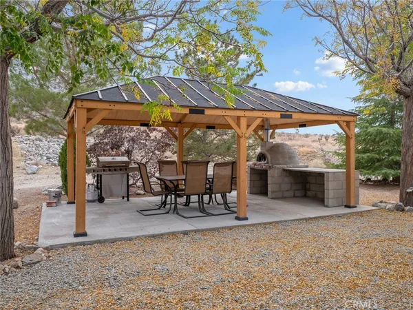 a view of a patio with a table and chairs under an umbrella