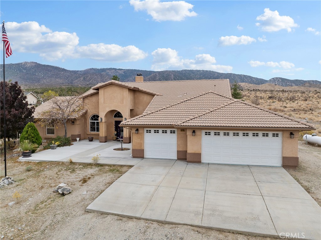 10160 Pineview Road Pinon Hills, CA 92372 - Photo 40 of 46 a view of a white house with a yard