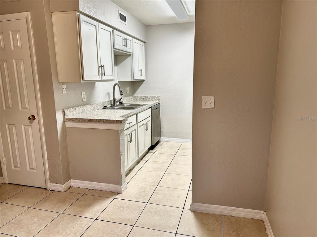 5801 Windhover Drive, Unit A01 Orlando, FL 32819 - Photo 5 of 14 a view of a kitchen with a sink and a stove top oven