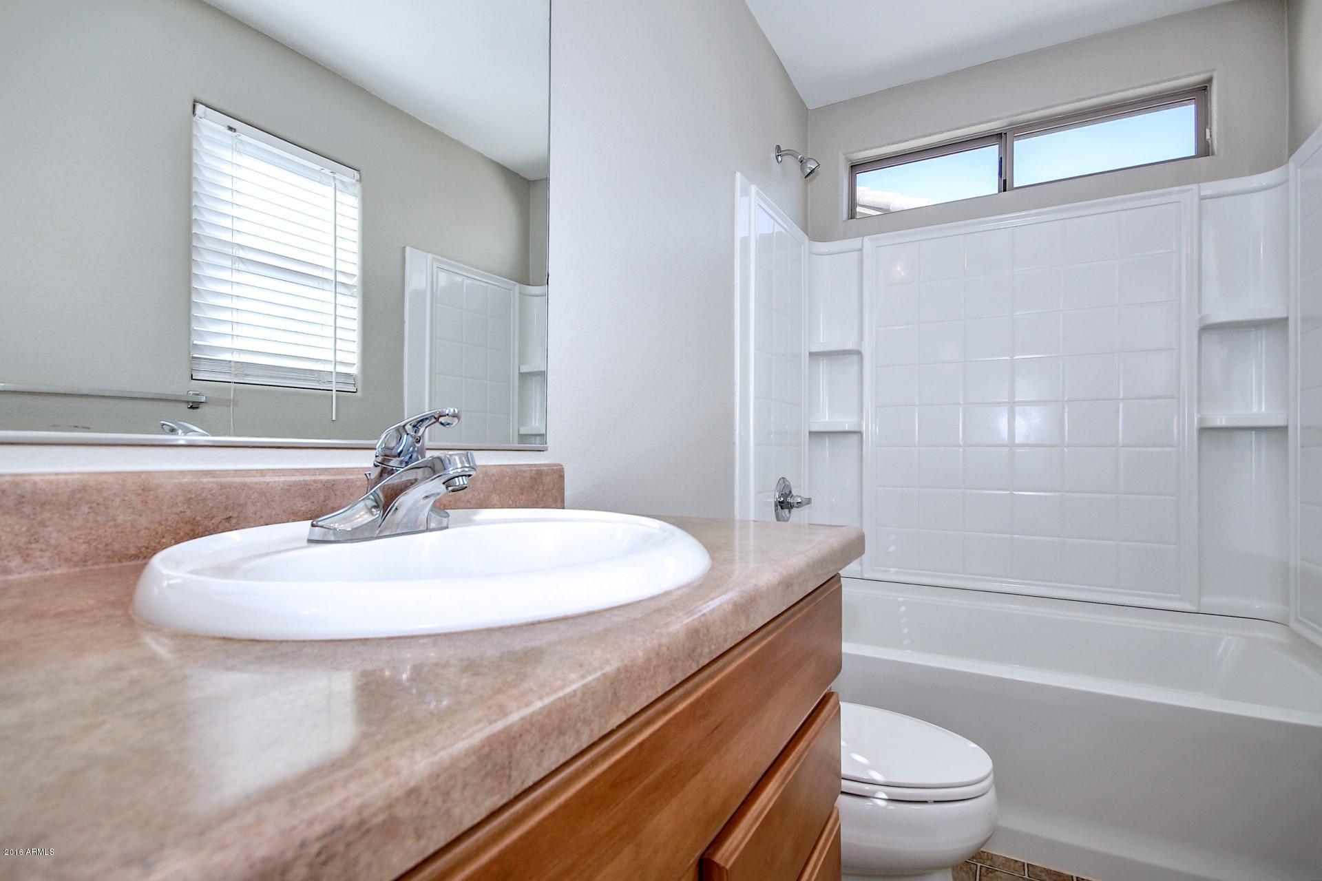 6416 West Beverly Road Laveen, AZ 85339 - Photo 13 of 22 a bathroom with a sink a toilet and a bathtub