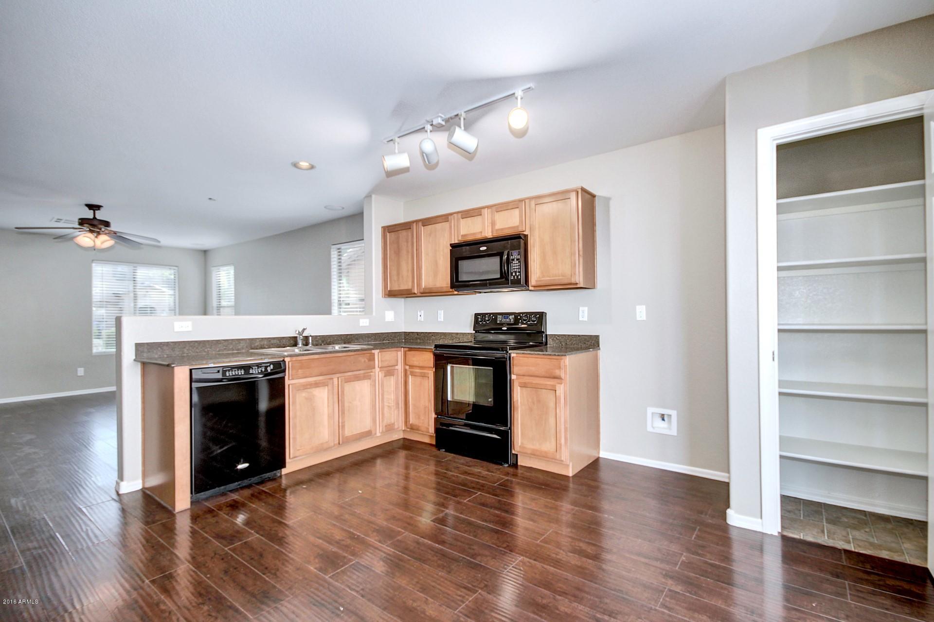 6416 West Beverly Road Laveen, AZ 85339 - Photo 3 of 22 a kitchen with granite countertop a stove top oven and cabinets
