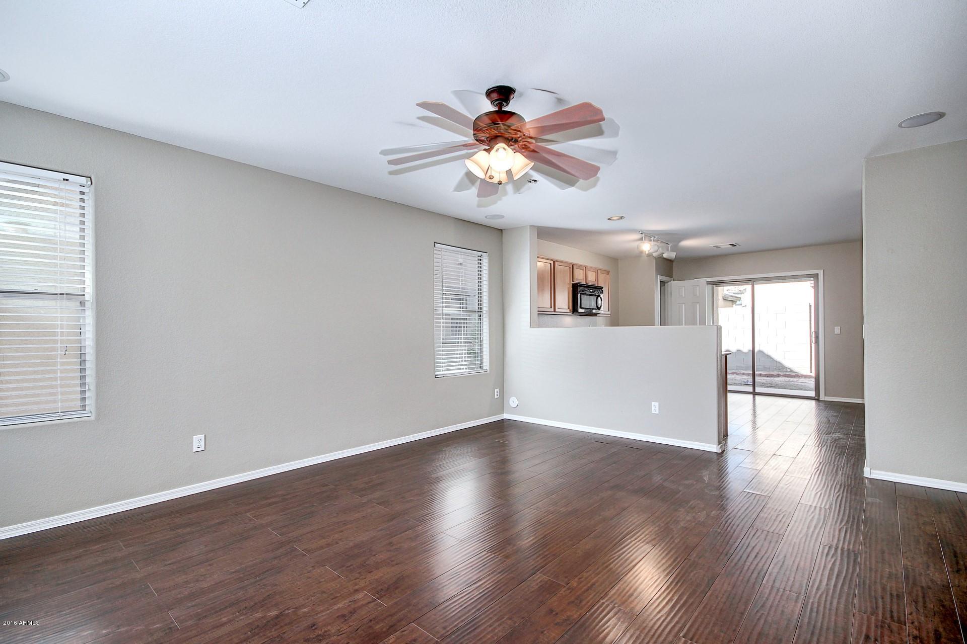 6416 West Beverly Road Laveen, AZ 85339 - Photo 7 of 22 a view of an empty room with window and wooden floor