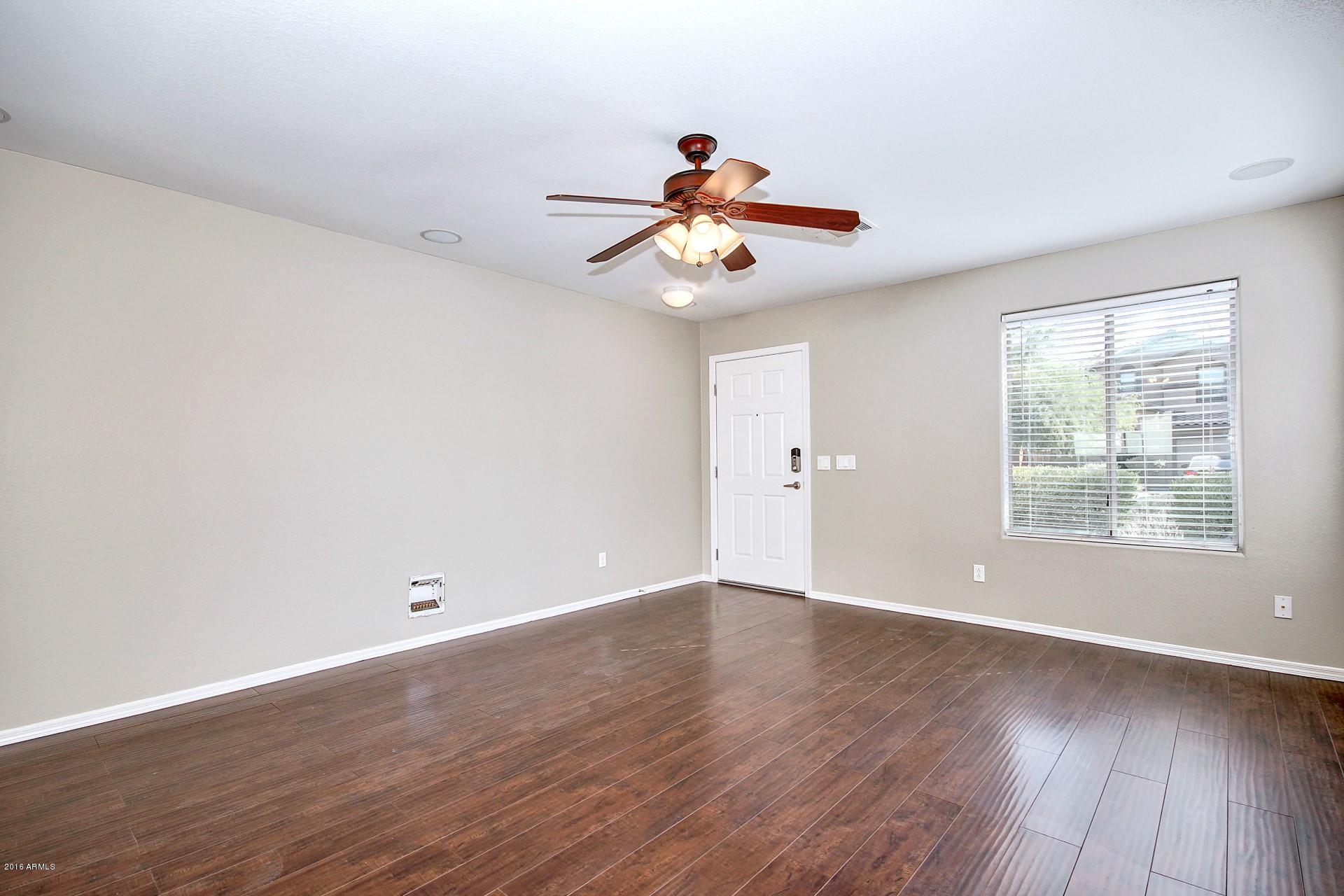 6416 West Beverly Road Laveen, AZ 85339 - Photo 8 of 22 a view of an empty room with wooden floor and a window