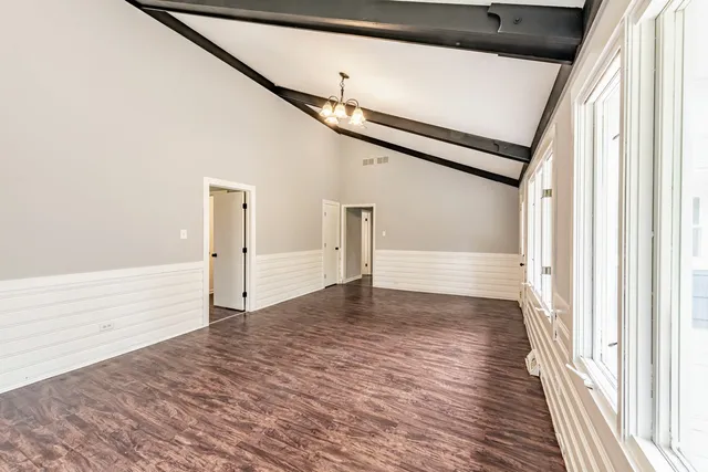 a view of empty room with wooden floor and stairs