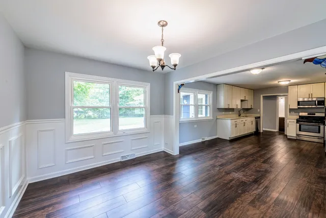 a view of a kitchen with wooden floor and windows
