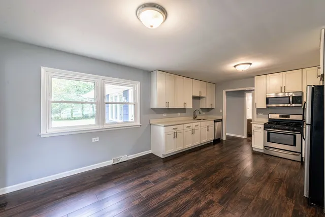 a kitchen with stainless steel appliances a refrigerator and a stove top oven