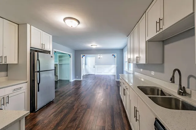 a kitchen with a refrigerator sink and cabinets