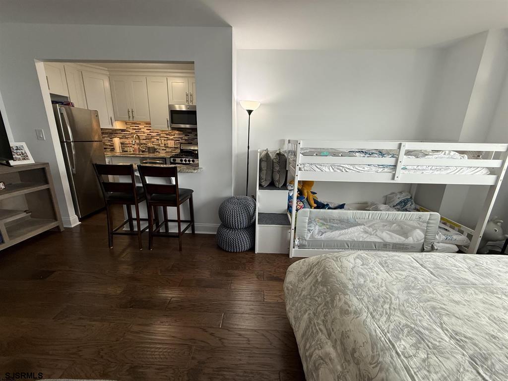 9400 Atlantic Avenue, Unit 306 Margate City, NJ 08402 - Photo 4 of 17 a bedroom with a bed and wooden floor