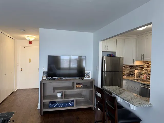 a kitchen with a refrigerator and a stove top open