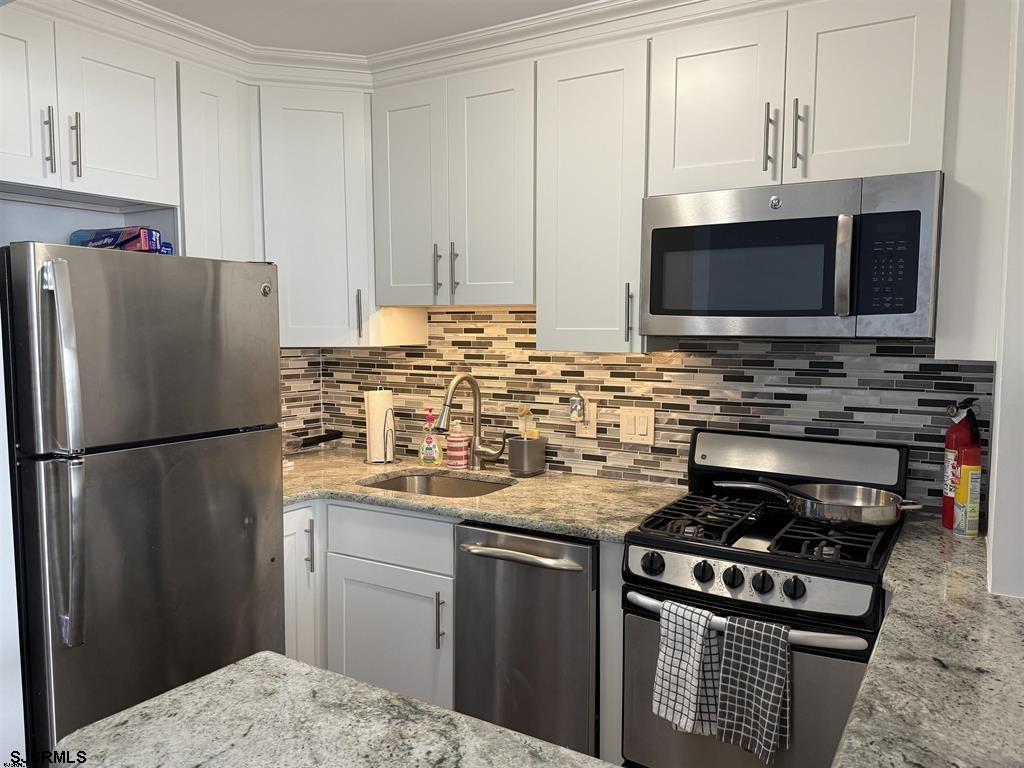 9400 Atlantic Avenue, Unit 306 Margate City, NJ 08402 - Photo 9 of 17 a kitchen with stainless steel appliances a stove a sink and a refrigerator