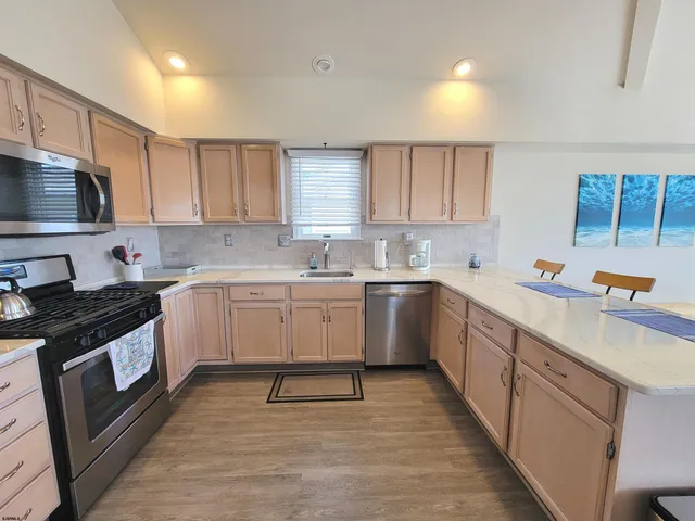 a kitchen with stainless steel appliances a stove a refrigerator and a microwave