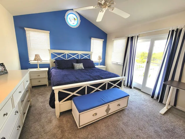 a bedroom with a large bed and flat tv screen on dresser