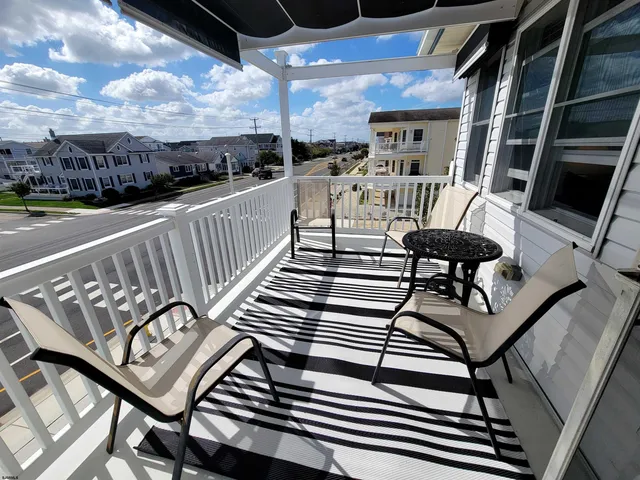 a view of a patio with table and chairs with wooden floor and fence