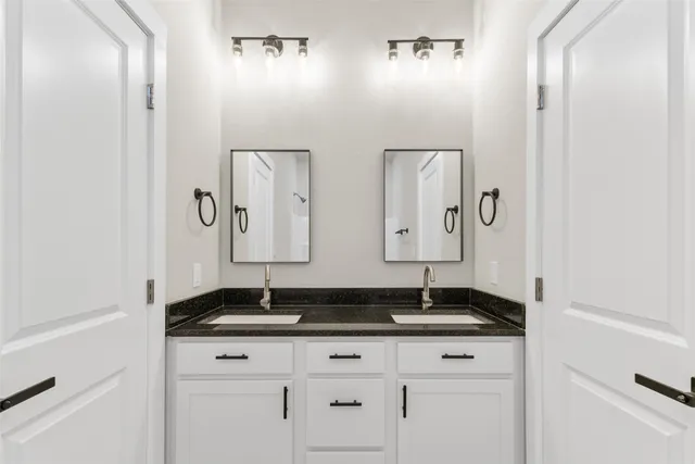 a bathroom with double sink and granite