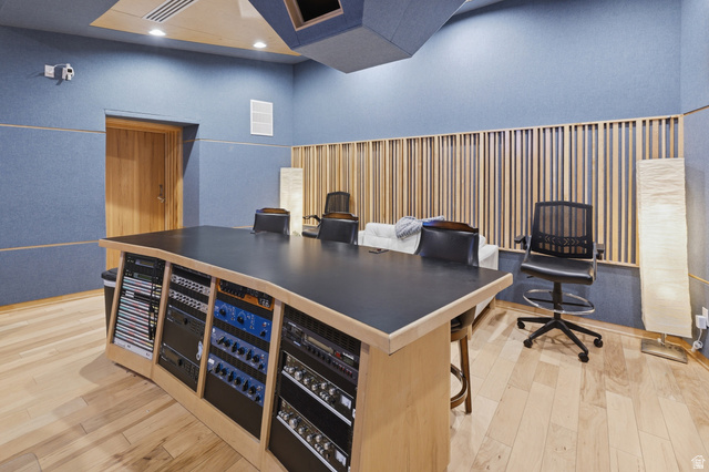 702 Alpine Highway Alpine, UT 84004 - Photo 72 of 83 Professional studio space featuring a large built-in console with integrated equipment racks, acoustically treated walls, a natural wood-finish door, wood slat wall accents, and light wood-finish flooring