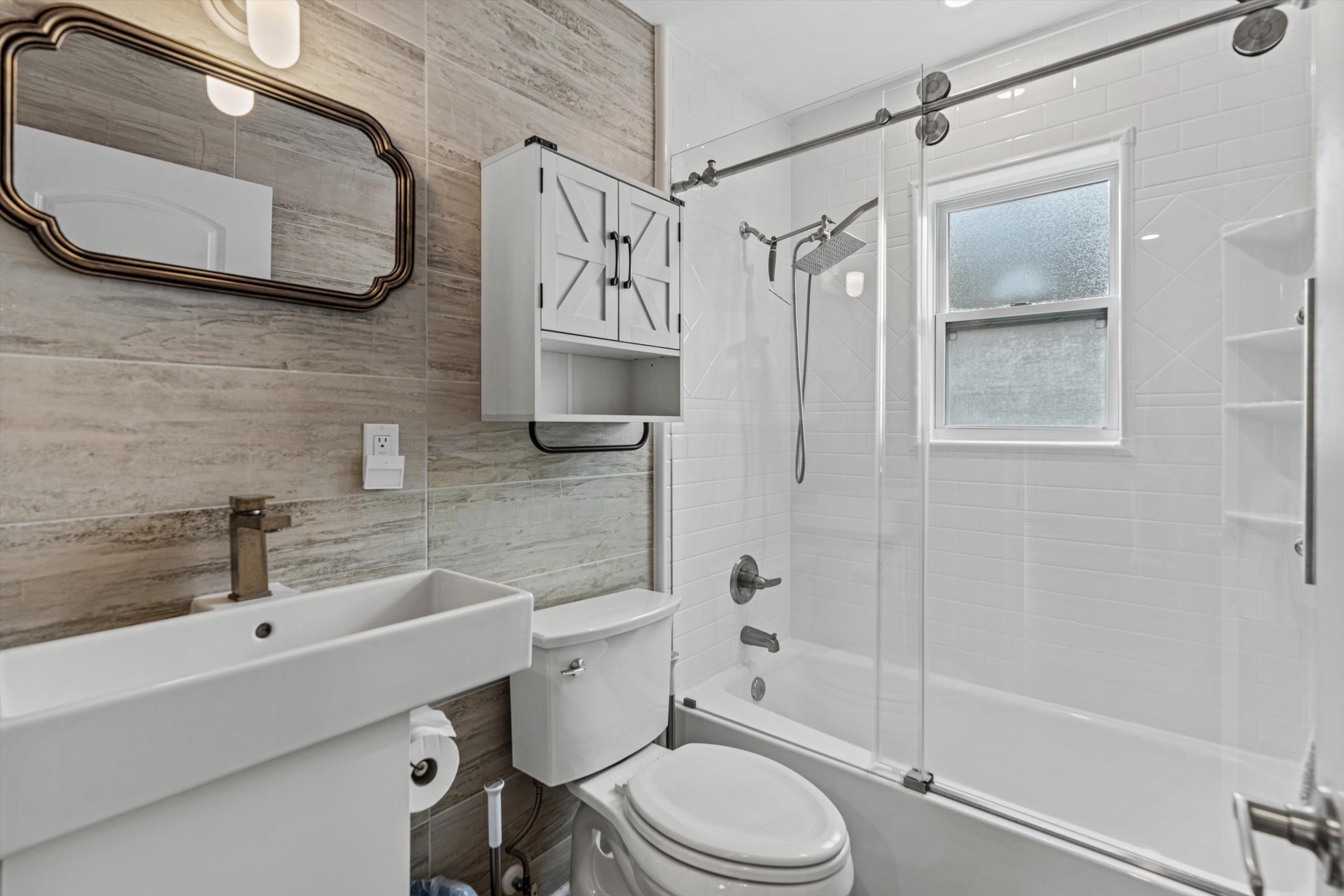 9 3rd Street, Unit UP St. Augustine, FL 32080 - Photo 18 of 24 a bathroom with a sink a toilet and shower