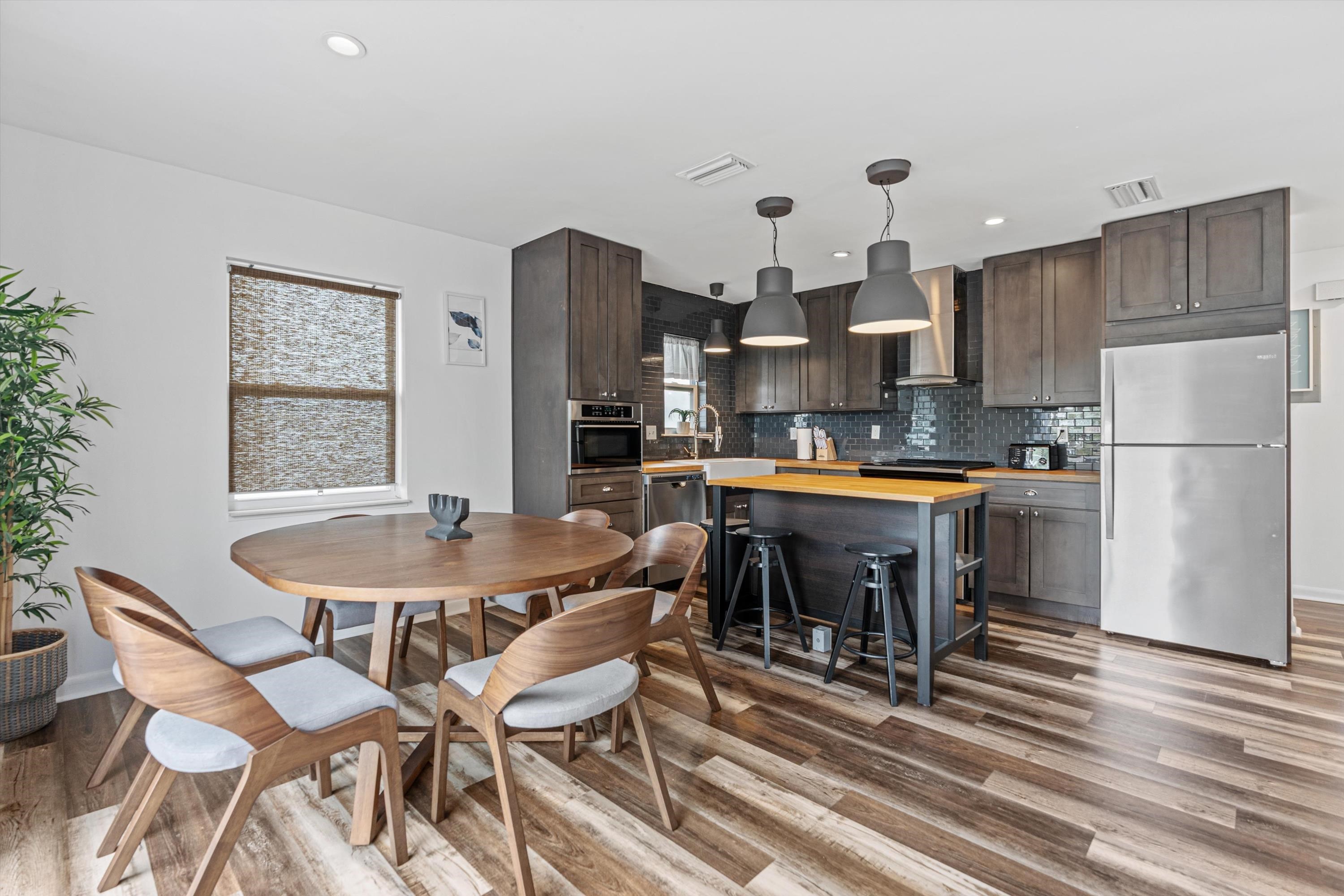 9 3rd Street, Unit UP St. Augustine, FL 32080 - Photo 10 of 24 a kitchen with stainless steel appliances granite countertop a table chairs and a refrigerator