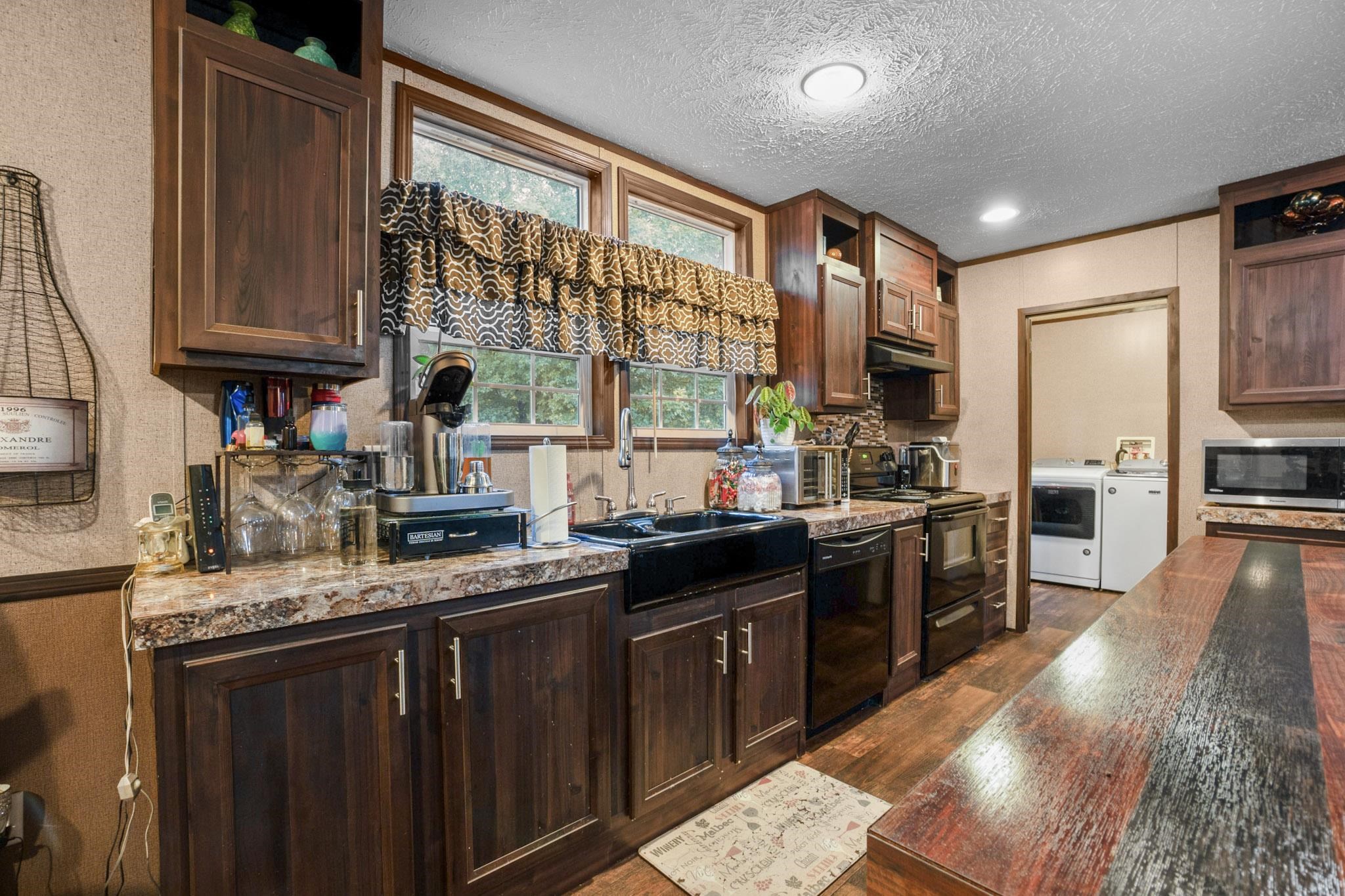 3779 Dancyville Road Stanton, TN 38069 - Photo 11 of 40 a kitchen with kitchen island granite countertop a sink appliances cabinets and a counter top space