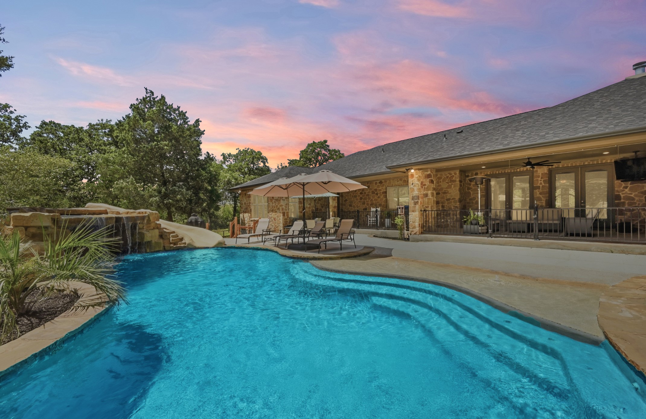 387 Corral Road Smithville, TX 78957 - Photo 29 of 40 Freeform swimming pool with integrated spa and rock waterfall feature