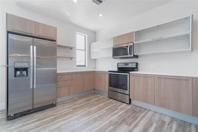a view of kitchen with cabinets table and chairs