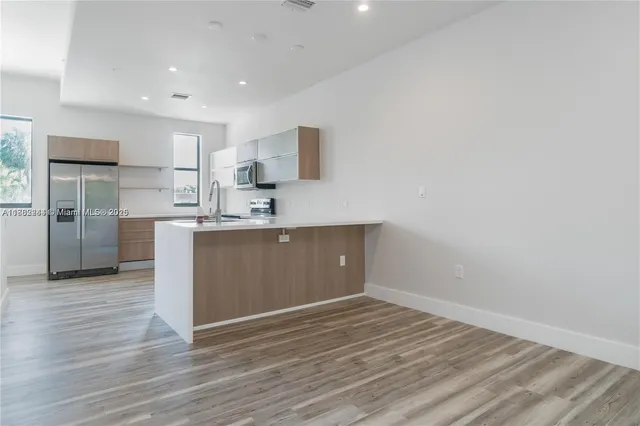 a view of a kitchen with wooden floor and a sink