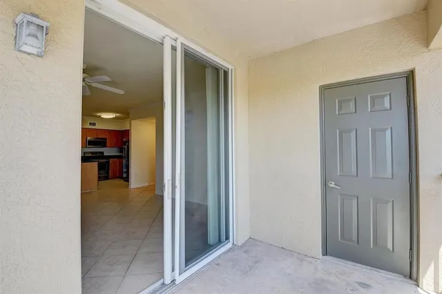 an empty room and a bathroom with sink