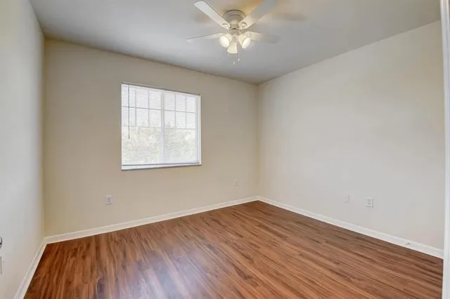 an empty room with a window and wooden floor