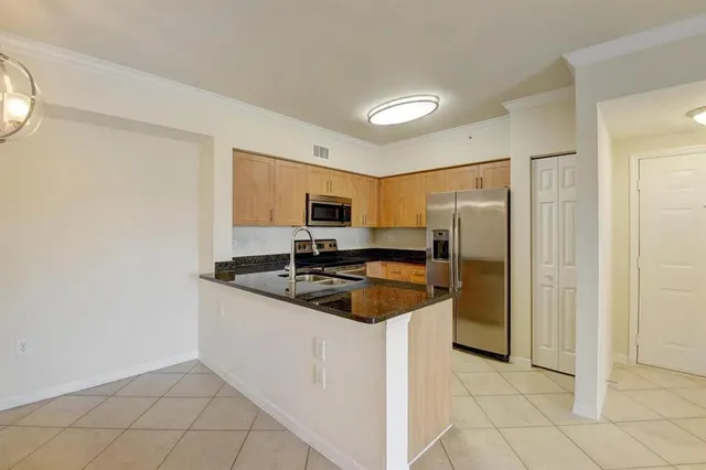 a kitchen with granite countertop a sink and a refrigerator