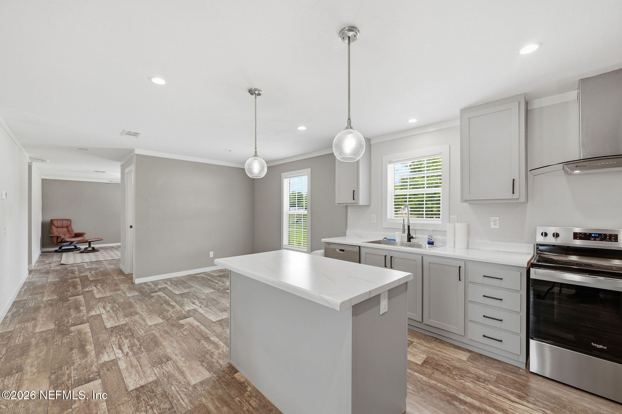 101 Oakhaven Road Pomona Park, FL 32181 - Photo 4 of 23 a large kitchen with kitchen island a stove a sink a center island and wooden floor