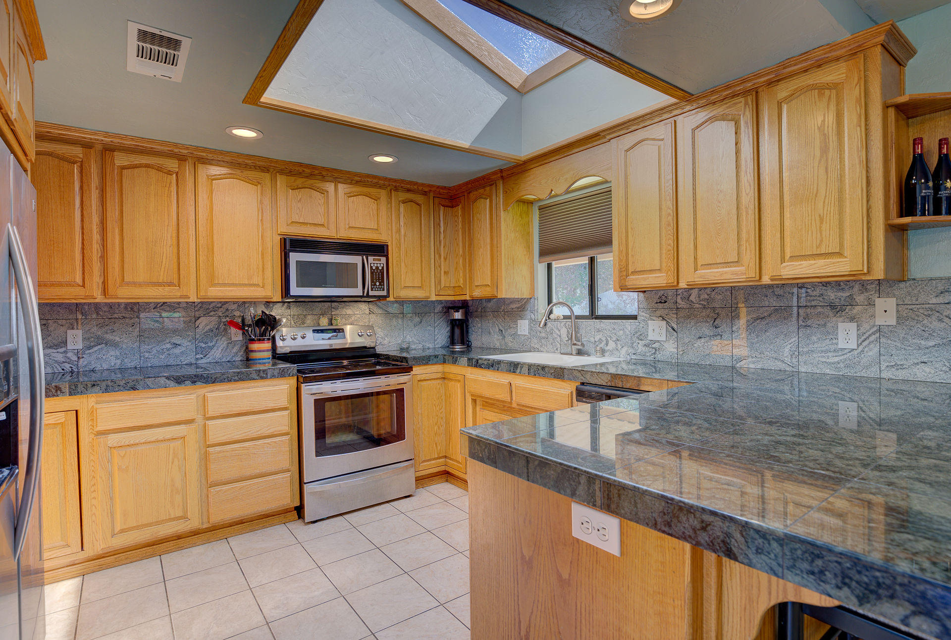 a kitchen with granite countertop a stove sink and cabinets
