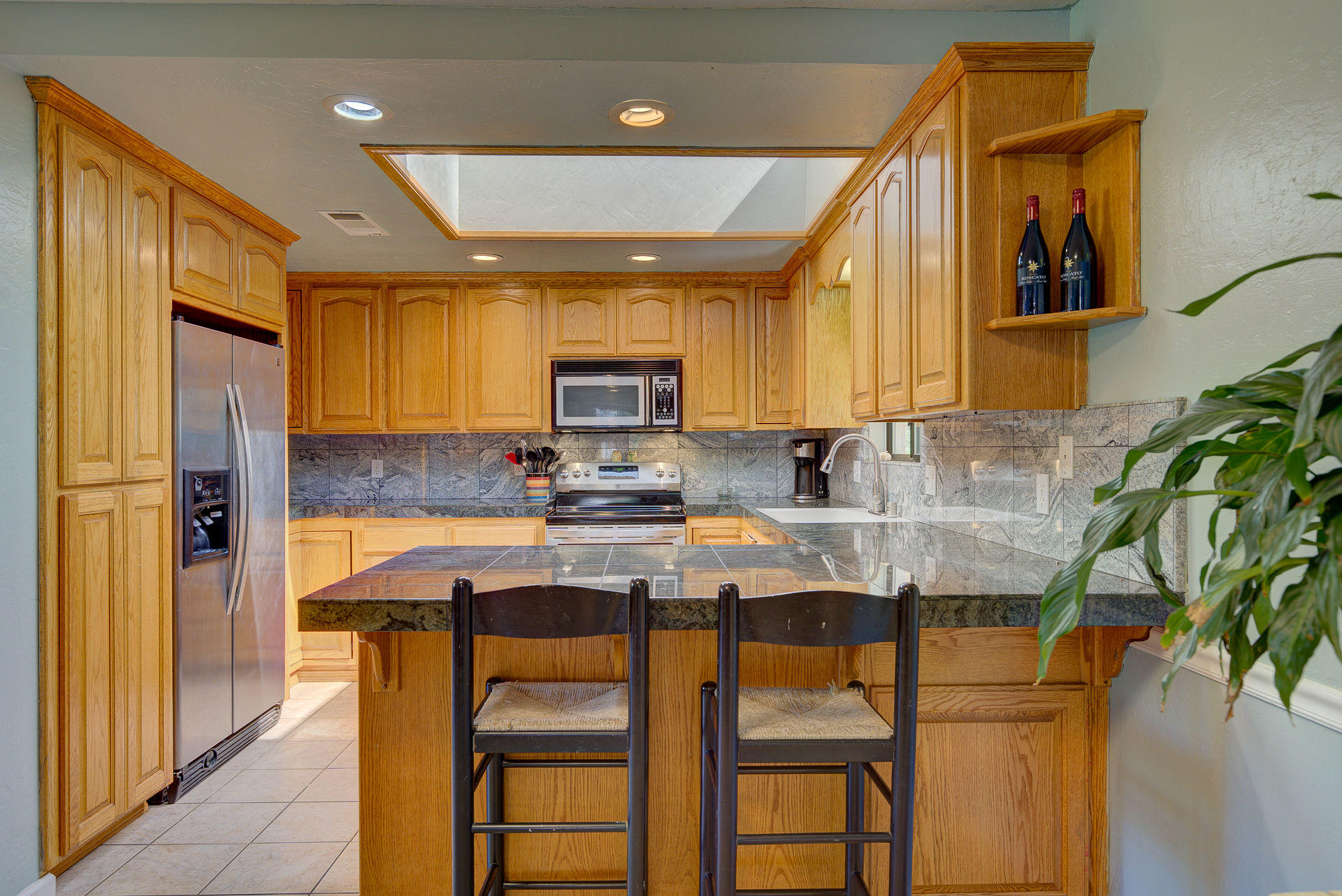 12814 Williamson Road Redding, CA 96003 - Photo 7 of 39 a kitchen with stainless steel appliances granite countertop table chairs cabinets and a potted plant