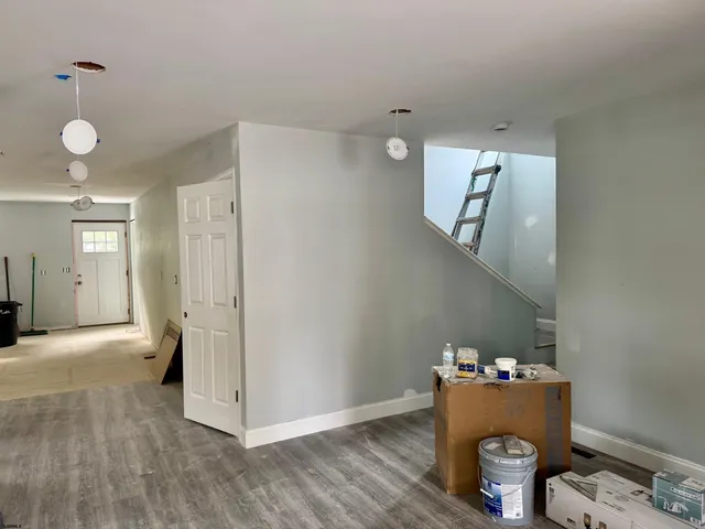 a view of hallway with furniture and wooden floor