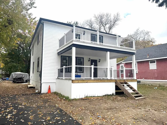 a view of a house with a yard and a large tree