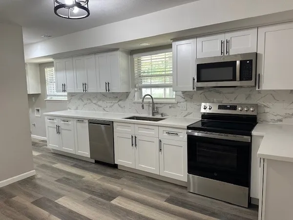 a kitchen with a sink stove and microwave