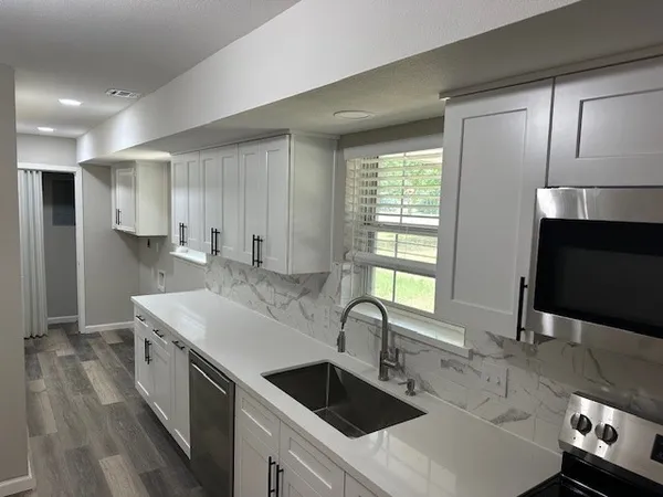 a kitchen with stainless steel appliances a sink stove and cabinets