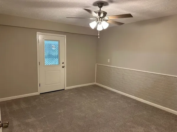 an empty room with a chandelier fan