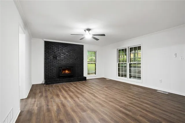 a view of empty room with wooden floor and fireplace