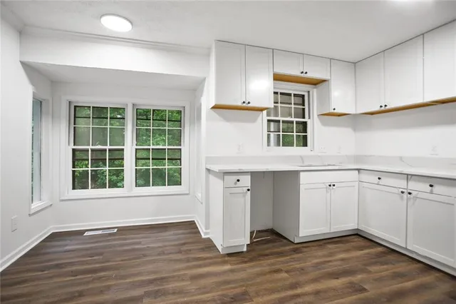 an empty room with wooden floor and window