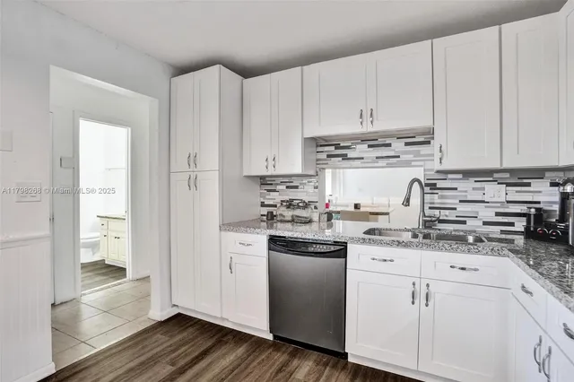 a kitchen with stainless steel appliances granite countertop a refrigerator sink and white cabinets