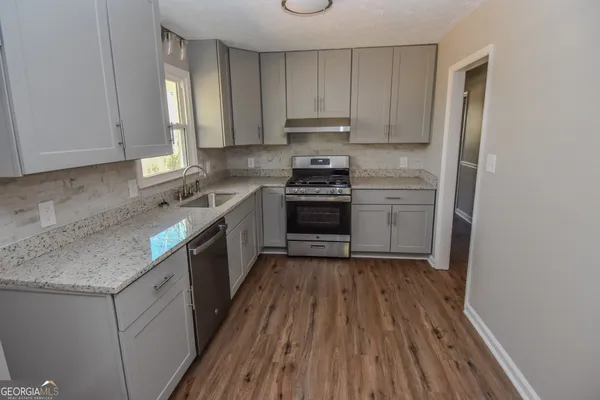 a kitchen with a sink stove and cabinets